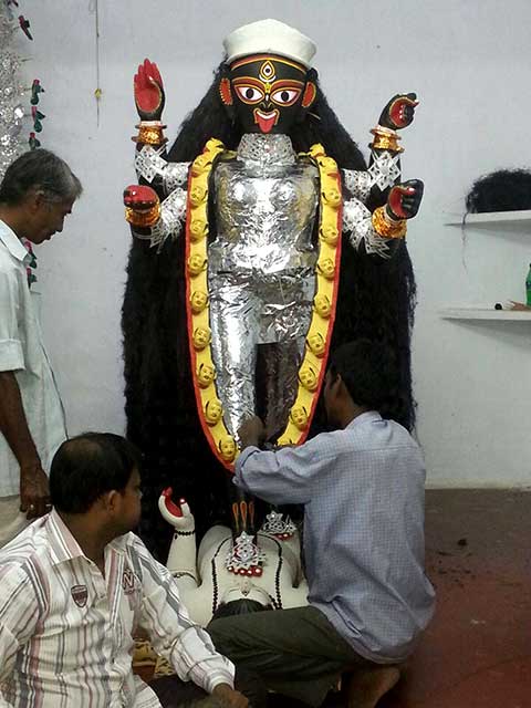 Foil paper being wrapped around the body before putting the dhaker saaj and the ornaments