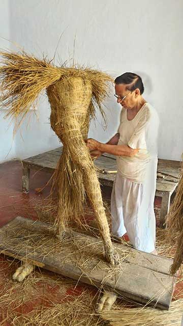 Artisan making straw structure of idol