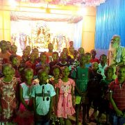 Santhal children standing in front of Durga Puja Pandal