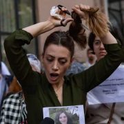 An iranian woman cutting herhair in protest against Hijab