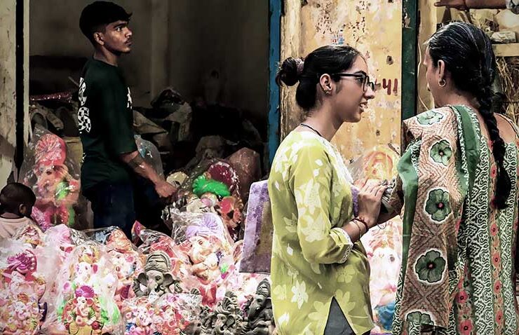 Finding the perfect fit for the festivities: shoppers share a lighthearted moment while selecting handcrafted Lord Ganesha idols at a lively festive market ahead of Ganesh Chaturthi.