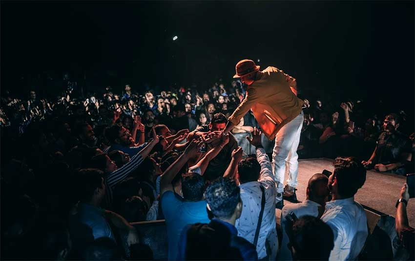Bridging the stage and the crowd: Zubeen Garg reaches out to connect with enthusiastic fans during a high-energy live performance.